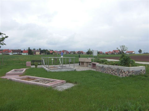 Kneippanlage mit verschiedenen Stationen auf einer Rasenfläche. Im Hintergrund ist die Siedlung zu sehen.