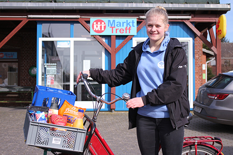 Eine junge Engagierte mit dem Elektro-Lastenrad vor dem MarktTreff Beidenfleth