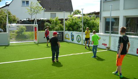 Fünf Kinder spielen Fussball auf dem Mini-Soccer-Field